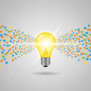 A glowing yellow lightbulb at the center, surrounded by a multitude of small, colorful speech bubbles emanating outwards from it, all on a light grey background. It symbolizes ideas or innovation sparked by diverse feedback.